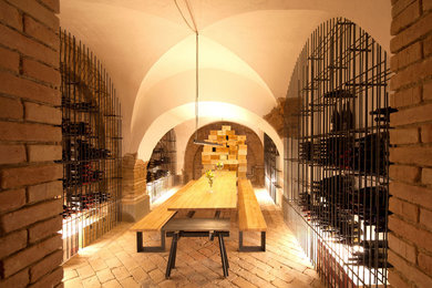 Exemple d'une grande cave à vin nature avec un sol en brique et des casiers losange.