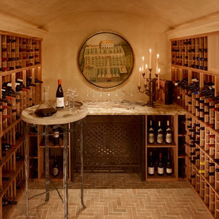 Foto de bodega mediterránea, de tamaño medio, con suelo de baldosas de terracota y botelleros