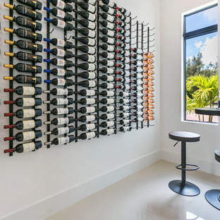 Immagine di una cantina minimal con rastrelliere portabottiglie e pavimento beige