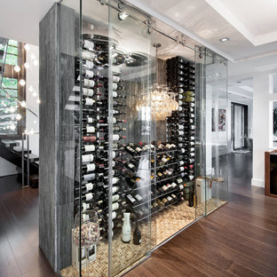Foto di una grande cantina design con parquet scuro, portabottiglie a vista e pavimento marrone