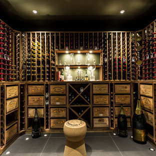 Cette image montre une cave à vin traditionnelle de taille moyenne avec un sol en carrelage de céramique et des casiers.