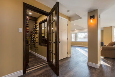 Mid-sized elegant dark wood floor and brown floor wine cellar photo in Toronto with display racks