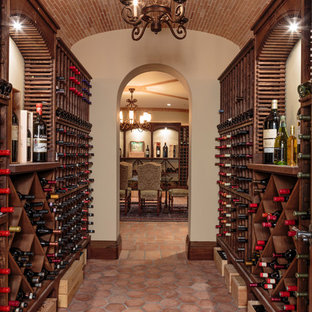 Foto di un'ampia cantina mediterranea con pavimento in terracotta, rastrelliere portabottiglie e pavimento rosso