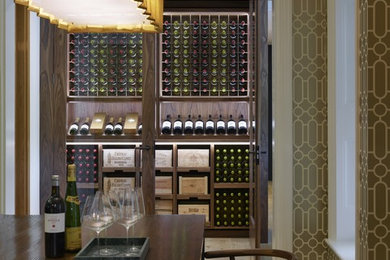 This is an example of a small traditional wine cellar in Kent with light hardwood flooring, display racks and brown floors.