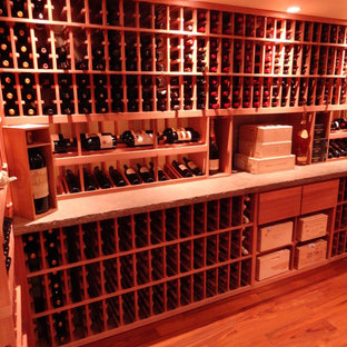 Ispirazione per una grande cantina shabby-chic style con parquet chiaro, rastrelliere portabottiglie e pavimento arancione