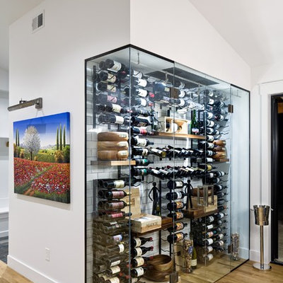 Example of a trendy light wood floor wine cellar design in Denver with storage racks