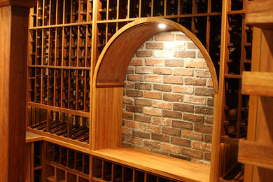 Large tuscan brick floor wine cellar photo in Los Angeles with storage racks