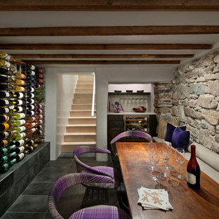 Immagine di una cantina mediterranea di medie dimensioni con pavimento in ardesia, portabottiglie a vista e pavimento grigio
