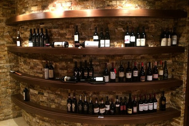 Large tuscan limestone floor wine cellar photo in Denver with display racks