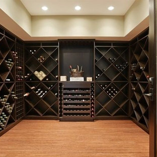 Immagine di una grande cantina minimal con pavimento in bambù e portabottiglie a scomparti romboidali