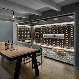 Immagine di una cantina contemporanea con portabottiglie a vista e pavimento grigio
