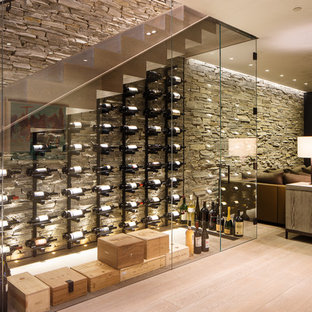Example of a mid-sized trendy light wood floor and beige floor wine cellar design in Denver with display racks