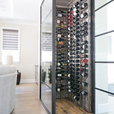 Wine cellar - small contemporary medium tone wood floor and beige floor wine cellar idea in Orange County with storage racks