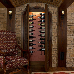 Foto de bodega tradicional, grande, con suelo de madera oscura, botelleros y suelo marrón
