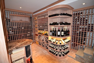 Large elegant travertine floor wine cellar photo in Charlotte with storage racks