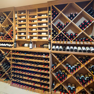 Ispirazione per una cantina country di medie dimensioni con pavimento in gres porcellanato, portabottiglie a vista e pavimento beige
