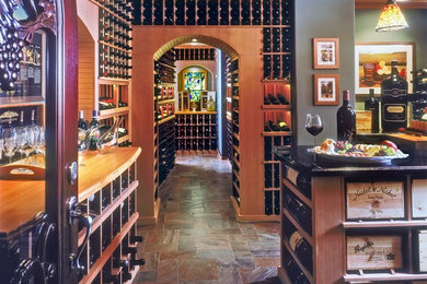 Wine cellar - large traditional terra-cotta tile wine cellar idea in San Diego with display racks