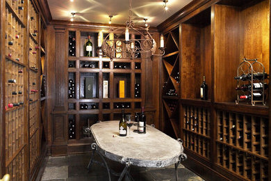 Large classic wine cellar in New York with storage racks, slate flooring and grey floors.