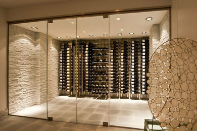 Example of a mid-sized trendy concrete floor and gray floor wine cellar design in New York with display racks