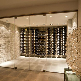 Idee per una cantina minimal di medie dimensioni con pavimento in cemento, portabottiglie a vista e pavimento grigio