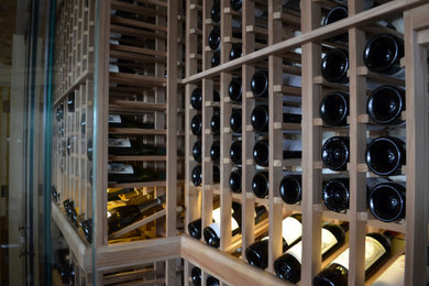 Mid-sized elegant dark wood floor and brown floor wine cellar photo in New York with storage racks