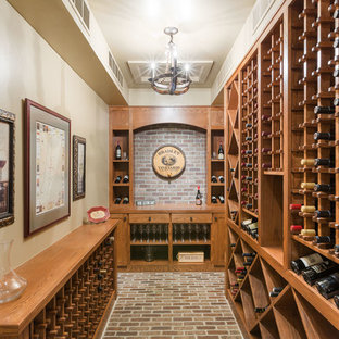 Ejemplo de bodega rústica, grande, con suelo de ladrillo, botelleros de rombos y suelo marrón