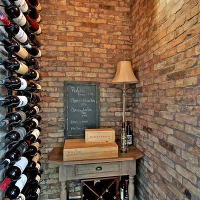 Wine cellar - traditional dark wood floor and red floor wine cellar idea in Austin with display racks