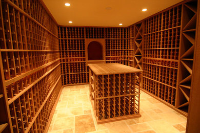 Rustik inredning av en stor vinkällare, med travertin golv och vinhyllor