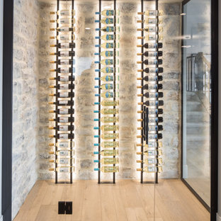 Immagine di una cantina country di medie dimensioni con pavimento in laminato, portabottiglie a vista e pavimento marrone