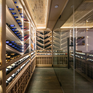 Idée de décoration pour une grand cave à vin tradition avec un sol en carrelage de porcelaine, un présentoir et un sol marron.