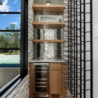 Imagen de bodega moderna, pequeña, con suelo laminado, botelleros y suelo beige