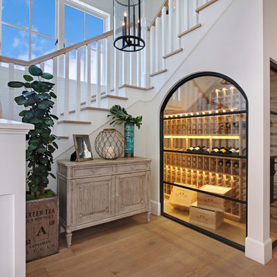 Inspiration for a coastal medium tone wood floor and yellow floor wine cellar remodel in Orange County with storage racks