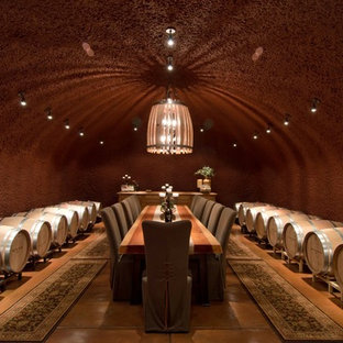 Idee per una cantina design con pavimento in cemento e pavimento arancione