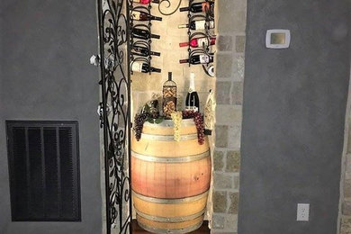 Wine cellar - mid-sized rustic dark wood floor and brown floor wine cellar idea in Houston with storage racks