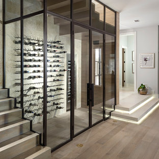 Ispirazione per una cantina minimal con parquet chiaro e rastrelliere portabottiglie