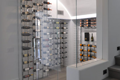 Wine cellar - mid-sized contemporary medium tone wood floor wine cellar idea in Orange County with display racks
