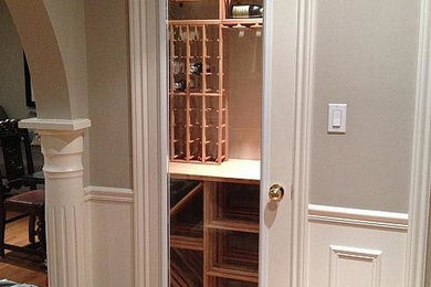 Medium sized contemporary wine cellar in Toronto with medium hardwood flooring, storage racks and brown floors.