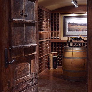 Ispirazione per una grande cantina chic con pavimento in cemento, rastrelliere portabottiglie e pavimento arancione