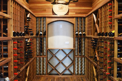 Elegant medium tone wood floor wine cellar photo in Austin with storage racks