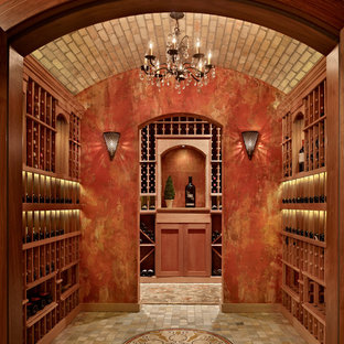 Ispirazione per una cantina mediterranea di medie dimensioni con pavimento in terracotta e portabottiglie a vista