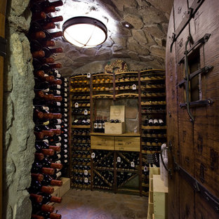 Ispirazione per una grande cantina stile rurale con rastrelliere portabottiglie, pavimento in cemento e pavimento marrone
