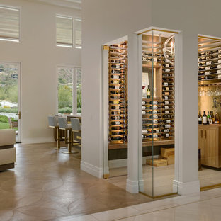 Immagine di una cantina design con rastrelliere portabottiglie e pavimento beige
