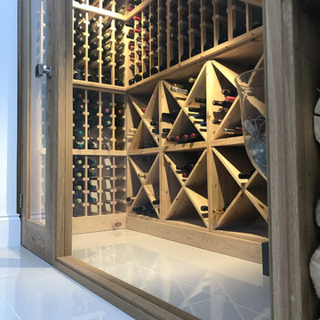 Luxury under stairs wine cellar in modern private home with a glass front