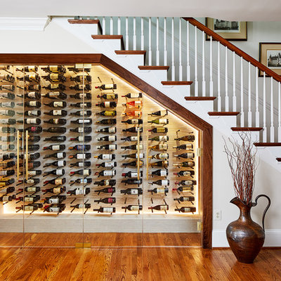 Inspiration for a timeless medium tone wood floor and orange floor wine cellar remodel in DC Metro with storage racks