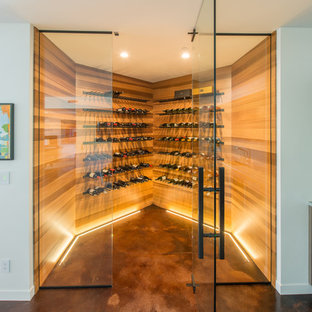 Foto de bodega contemporánea, grande, con botelleros, suelo marrón y suelo de cemento
