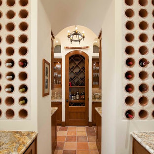 Inspiration pour une cave à vin méditerranéenne avec un sol en carreau de terre cuite et des casiers.