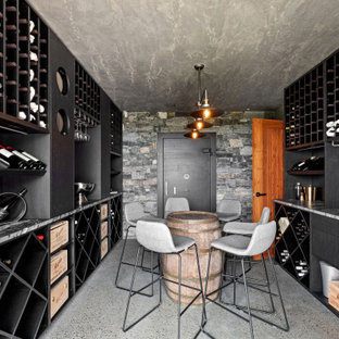 This is an example of a contemporary wine cellar in Sunshine Coast with concrete floors, storage racks and grey floor.