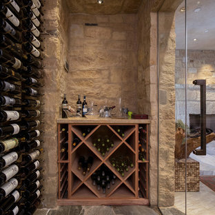 Inspiration pour une cave à vin traditionnelle de taille moyenne avec un sol en calcaire et des casiers.