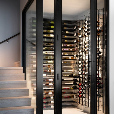 Wine cellar - mid-sized contemporary light wood floor and brown floor wine cellar idea in Miami with storage racks