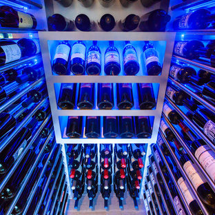 Aménagement d'une petit cave à vin moderne avec un sol en bois clair et un présentoir.